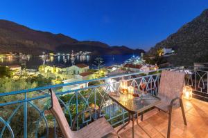 a balcony with a table and chairs and a view at Royal Villa Pedi in Symi