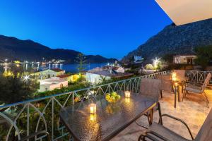 a balcony with a table with fruit on it at Royal Villa Pedi in Symi