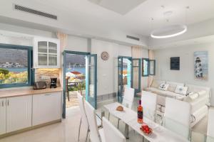 a kitchen and living room with a table and chairs at Royal Villa Pedi in Symi
