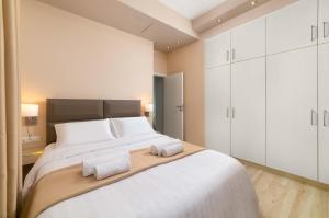 a bedroom with a large bed with two towels on it at Royal Villa Pedi in Symi