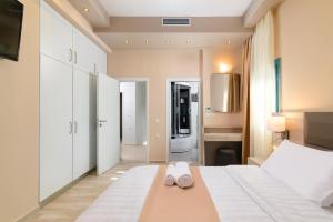 a bedroom with a bed with two slippers on it at Royal Villa Pedi in Symi