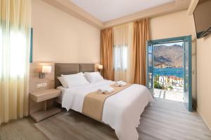 a hotel room with a bed and a large window at Royal Villa Pedi in Symi +37 photos