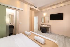 a bedroom with a bed and a tv on the wall at Royal Villa Pedi in Symi