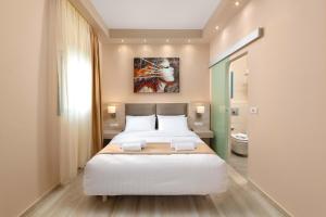 a bedroom with a large white bed and a bathroom at Royal Villa Pedi in Symi