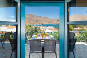 a table and chairs on a balcony with a view of the ocean at Royal Villa Pedi in Symi