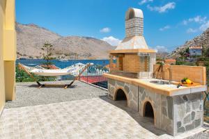 a outdoor kitchen with a sink and a hammock at Royal Villa Pedi in Symi