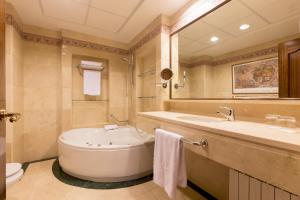 a bathroom with a large tub and a sink at Hotel Exe Reina Isabel in Ávila