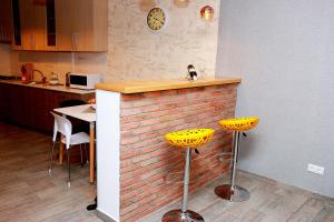 cocina con encimera de ladrillo y 2 taburetes amarillos en Tbilisi Trinity Apartment, en Tiflis 12 fotos más