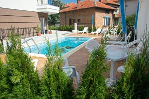 a pool with chairs and a table next to a house at Old Sailor Apartment in Obzor