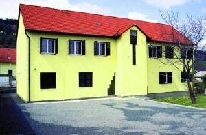 ein gelbes und rotes Haus mit rotem Dach in der Unterkunft Szamárkút Panzió in Pécs