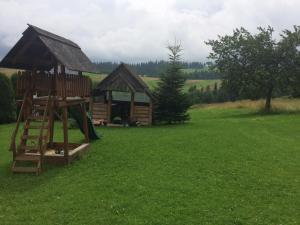 a log cabin with a slide and a playground at Pokoje u Staszka in Bukowina Tatrzańska +6 photos
