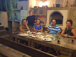 a group of people sitting around a table with food at Karya Apartments in Koycegiz