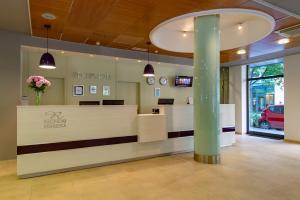 a reception area of a car dealership with a pillar at Hotel Regnum Residence in Budapest