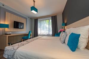 Un pat sau paturi într-o cameră la Hotel Regnum Residence