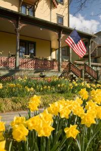 una casa con bandera americana y flores amarillas en The Queen Victoria, en Cape May