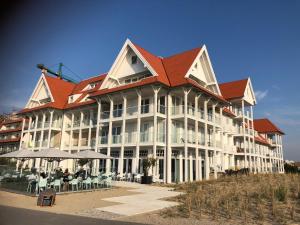 a large white building with a red roof at Penthouse in Badhuis Cadzand in Cadzand