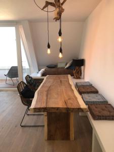 a dining room with a wooden table and a bed at Penthouse in Badhuis Cadzand in Cadzand +69 photos