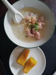 Duas tigelas de sopa e um prato de comida. em BanJankapor em Kaeng Krachan