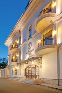ein großes weißes Gebäude mit Balkon auf einer Straße in der Unterkunft Villa Le Premier Maestro in Odessa