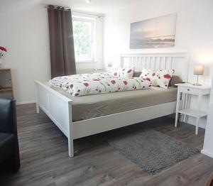 a bedroom with a white bed with pillows and a window at Ferienwohnung Weinklang in Volkach