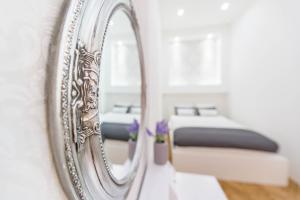 um espelho numa parede com duas camas num quarto em Dominik Apartment em Budapeste