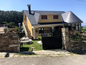 a house with a black gate in front of it at O Capricho in Barizo