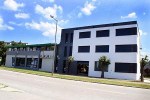 a white building on the side of a street at Hotel Fitromax Ajka in Ajka