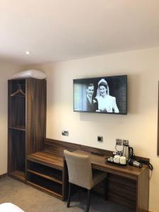 a room with a desk with a tv on the wall at Rivington Lodge in Bolton