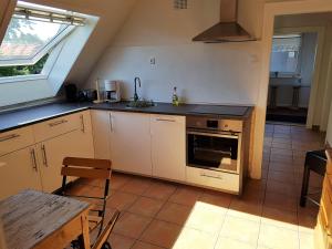 a kitchen with white cabinets and a stove top oven at Apartment am Park in Lehrte