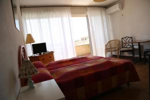 1 dormitorio con cama y ventana grande en Résidence Créole, en Valras-Plage