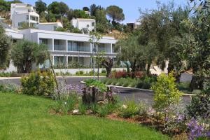 a garden in front of a white building at Rodostamo Hotel & Spa- Adults Friendly in Kommeno