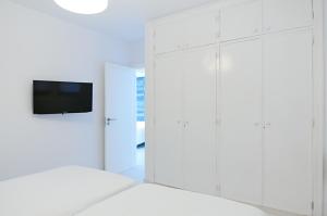 a bedroom with white cabinets and a tv at Villas Pasito Blanco in Pasito Blanco