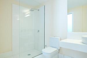 a white bathroom with a shower and a toilet at Villas Pasito Blanco in Pasito Blanco