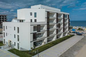 a white building with the ocean in the background at Apartament La Plaja in Mamaia Nord