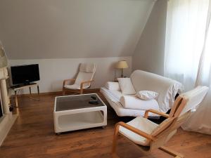 a living room with a couch and chairs and a tv at Apartment am Park in Lehrte