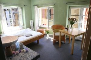 ein Schlafzimmer mit einem Bett, einem Tisch und einem sidx sidx sidx in der Unterkunft Le Café-Hôtel de L'Aubier in Neuenburg