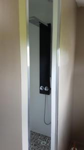 a bathroom with a shower with a television on the wall at La THIBAUDIERE Tilleul in Châlus +13 photos