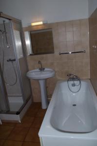 a bathroom with a tub and a sink and a shower at Résidence Créole in Valras-Plage