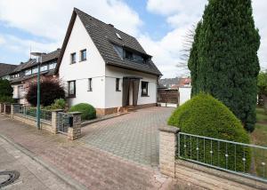 ein weißes Haus mit einem schwarzen Dach und einer Auffahrt in der Unterkunft Ferienhaus Angela in Hameln