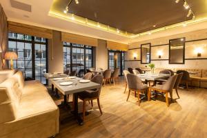 a restaurant with tables and chairs and a couch at Aksent Hotel in Baku