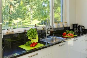 una cucina con lavandino e verdure su un bancone di Lotsenstieg 11 a Ostseebad Karlshagen