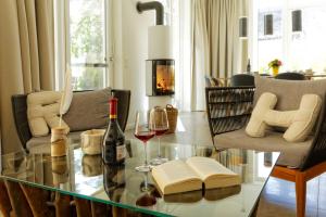 Sala de estar con mesa de cristal y 2 copas de vino en Lotsenstieg 13b, en Ostseebad Karlshagen