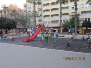 ein Spielplatz mit Kindern, die auf einer Rutsche spielen in der Unterkunft los locos San Pascual in Torrevieja
