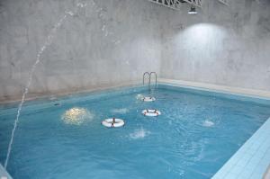 Dos personas están nadando en una piscina en Al Salam Royal Hotel Suites, en Taif