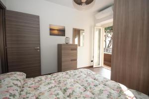 1 dormitorio con 1 cama y puerta de madera en Il Golfo Apartment, en Lenno