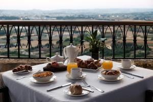 a table with breakfast food on it with a view at The Xara Palace Relais & Chateaux in Mdina