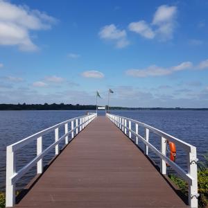 een houten pier strekt zich uit over het water bij Marina View in Bad Zwischenahn