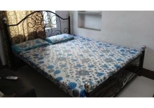 a bed with a blue and white quilt on it at Budget rooms on VIP road in Pushkar