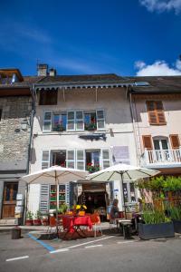 two tables and umbrellas in front of a building at L'Atelier Du Peintre in Ornans