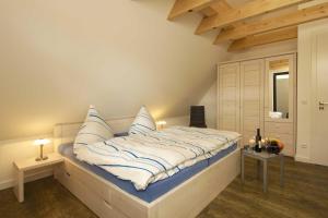 a bedroom with a bed with blue and white pillows at Kapitaensweg 28 in Ostseebad Karlshagen